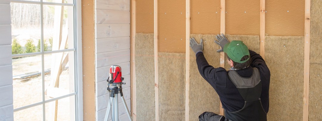 Man isoleert een voorzetwand met steenwolplaten in een oud huis